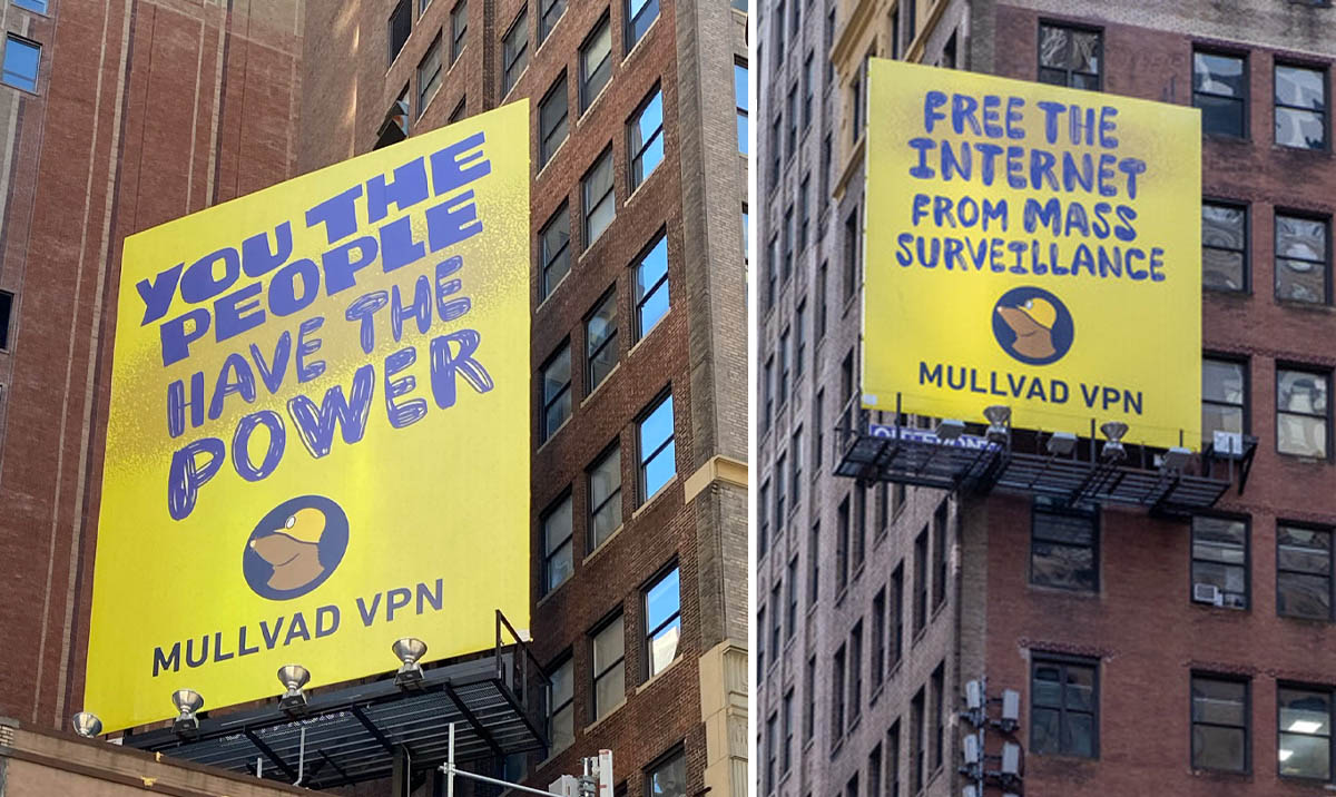 Two yellow Mullvad VPN billboards on brick buildings: "YOU THE PEOPLE HAVE THE POWER" and "FREE THE INTERNET FROM MASS SURVEILLANCE".